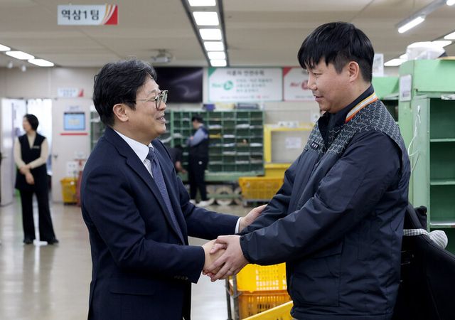 박인환 우정사업본부장(왼쪽)이 서울강남우체국을 방문해 최근 우편물 배달 중 의식을 잃은 시민을 구한 유상범 집배원(오른쪽)을 격려하고 있다. [사진=우정사업본부]