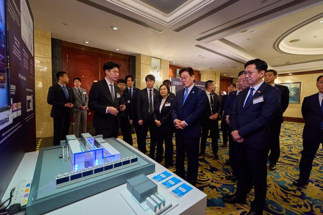 이재명&nbsp;대통령이 2일 싱가포르의 한 호텔에서 열린 한-싱가포르 AI 커넥트 서밋이 끝난 뒤 한 전시 업체 관계자로부터 AI 반도체 제품 상용화 사례에 대한 설명을 듣고 있다. [사진=청와대]