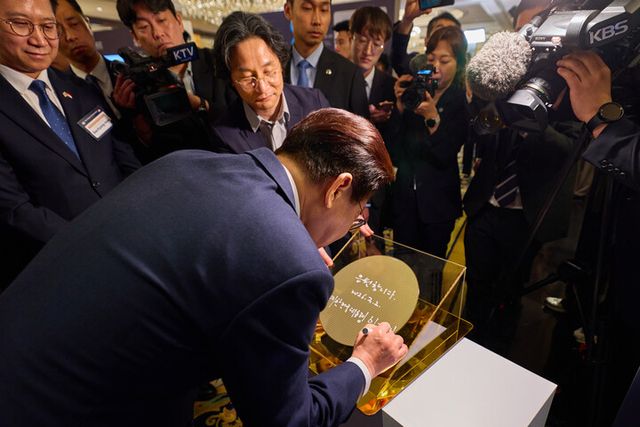 이재명 대통령이 2일 싱가포르의 한 호텔에서 열린 한-싱가포르 AI 커넥트 서밋이 끝난 뒤 한 전시업체가 준비한 웨이퍼에 서명하고 있다. [사진=청와대]