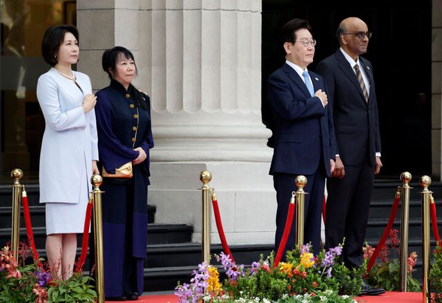 이재명 대통령과 김혜경 여사가 2일 싱가포르 외교부 청사에서 열린 국빈방문 환영식에서 국기에 경례하고 있다. 이 대통령 오른쪽은 타르만 샨무가라트남 싱가포르 대통령. [사진=연합뉴스]