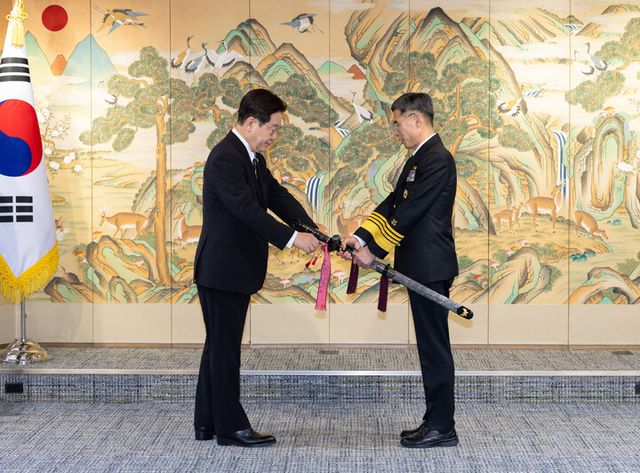 이재명 대통령이 27일 서울 용산 국방부에서 김경률 신임 해군참모총장에게 삼정검 수치를 수여하고 있다. [사진=청와대]