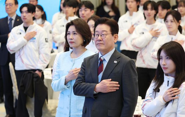 이재명 대통령과 김혜경 여사가 5일 청와대 영빈관에서 열린 2026 밀라노-코르티나담페초 동계올림픽 선수단 격려 오찬에서 국기에 경례하고 있다. [사진=연합뉴스]