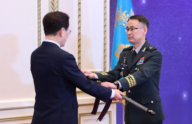 이재명 대통령이 6일 청와대 영빈관에서 열린 2026년 준장 진급 장성 삼정검 수여식에서 김문상 합참 민군작전부장에게 삼정검을 수여하고 있다. [사진=연합뉴스]