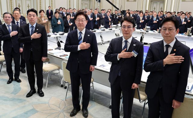 이재명 대통령이 17일 청와대 영빈관에서 열린 공공기관 및 유관기관 업무보고에서 국민의례를 하고 있다. (오른쪽부터) 배경훈 부총리 겸 과학기술정보통신부 장관, 김민석 국무총리, 이 대통령, 강훈식 비서실장, 김용범 정책실장.&nbsp; [사진=연합뉴스]