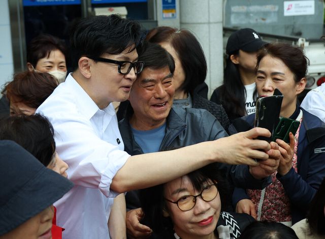 한동훈 전 국민의힘 대표가 14일 오후 부산 북구 만덕2동 행정복지센터를 찾아 전입신고를 마친 뒤 주민들과 사진을 찍고 있다.[사진=연합뉴스]