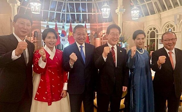 베트남을 국빈 방문한 이재명 대통령과 김혜경 여사가 22일(현지 시각) 하노이 영빈관에서 열린 국빈 환영만찬에서 또 럼 베트남 공산당 서기장 겸 국가주석 부부 및 베트남 전·현직 축구대표팀 감독과 기념촬영을 하고 있다. (왼쪽부터) 김상식 현 베트남 축구 대표팀 감독, 김혜경 여사, 또 럼 서기장, 이재명 대통령, 응오 프엉 리 여사, 박항서 전 베트남 축구 대표팀 감독. [사진=연합뉴스]