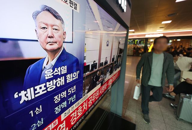 고위공직자범죄수사처 체포방해 등 혐의로 기소된 윤석열 전 대통령의 항소심 선고 공판 생중계 방송이 29일 서울역 대합실에서 TV를 통해 송출되고 있다.[사진=연합뉴스]
