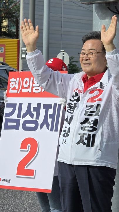 김성제 의왕시장 후보가 거리 유세 현장에서 시민들에게 손을 들어 인사하며 지지를 호소하고 있다.[사진=김성제 후보 캠프 제공]