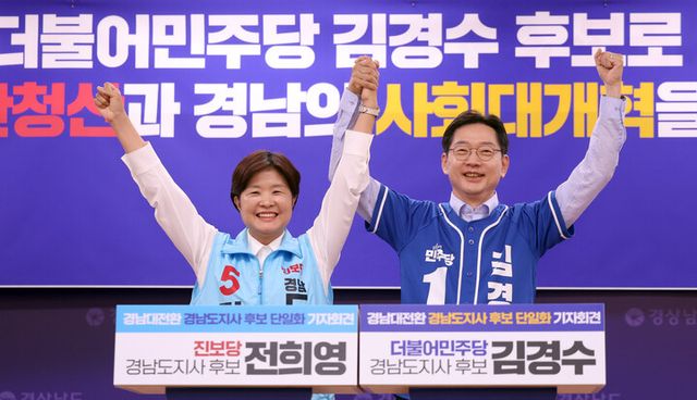 더불어민주당 김경수 경남지사 후보와 진보당 전희영 후보가 27일 오후 경남도청 프레스센터에서 열린 '경남대전환 경남도지사 후보 단일화' 긴급 기자회견에서 손을 들어 인사하고 있다.두 정당은 김경수 후보로 단일화했다[사진=연합뉴스]