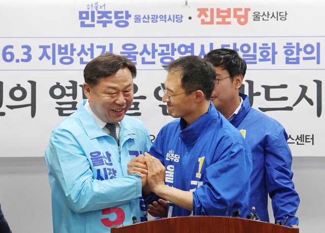 15일 울산시의회 프레스센터에서 더불어민주당 울산시당과 진보당 울산시당이 6·3 지방선거&nbsp;울산시장&nbsp;후보 단일화 합의를 발표한 후 민주당 김상욱(오른쪽)·진보당 김종훈&nbsp;울산시장&nbsp;후보가 손을 맞잡고 있다.[사진=연합뉴스]
