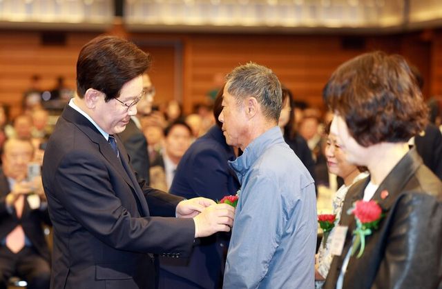 이재명 대통령이 8일 서울 중구 대한상공회의소에서 열린 어버이날 기념식에서 순직 소방관, 경찰관 부모님들에게 카네이션을 달아드리고 있다. [사진=연합뉴스]