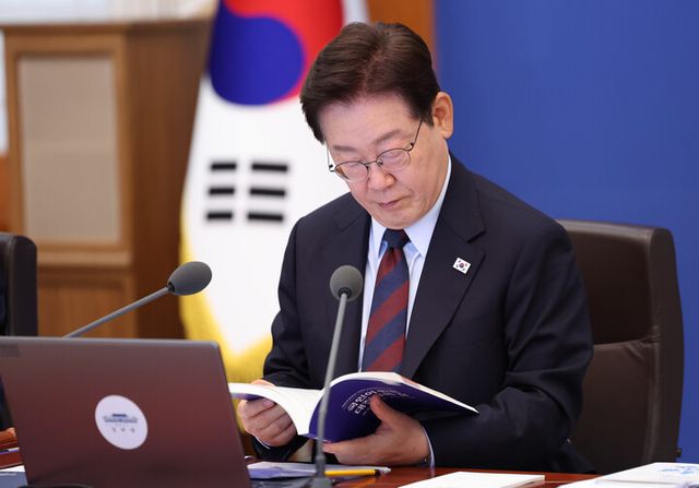 이재명 대통령이 지난달 26일 청와대에서 열린 국무회의 겸 비상경제점검회의에서 정부출범 1주년 성과자료집을 보고 있다. [사진=연합뉴스]