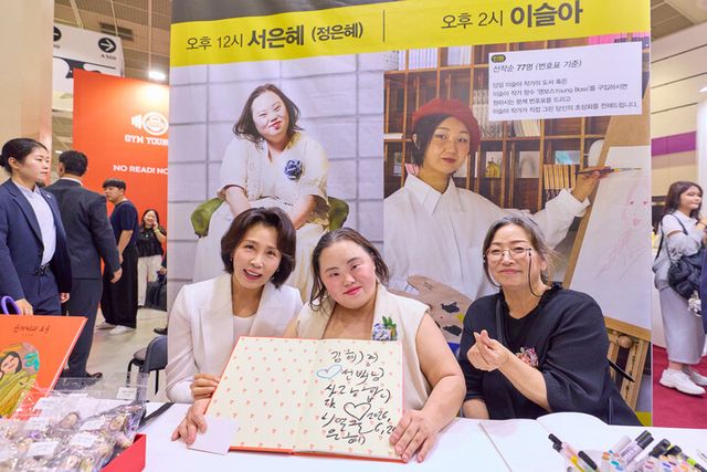김혜경 여사가 24일 서울 강남구 코엑스에서 열린 서울국제도서전에서 정은혜 작가, 정 작가 어머니인 장차현실 작가와기념촬영을 하고 있다. [사진=청와대]