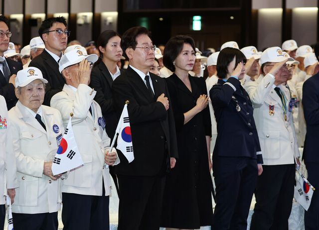 이재명 대통령과 김혜경 여사가 25일 수원컨벤션센터에서 열린 6·25전쟁 제76주년 기념식에서 국기에 경례하고 있다. [사진=연합뉴스]