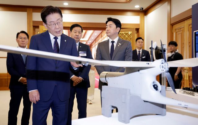 이재명 대통령이 26일 청와대에서 열린 '미래신안보 혁신기업 육성전략' 회의에 앞서 행사장 전시물인 정찰용 무인항공기를 보고 있다. [사진=연합뉴스]