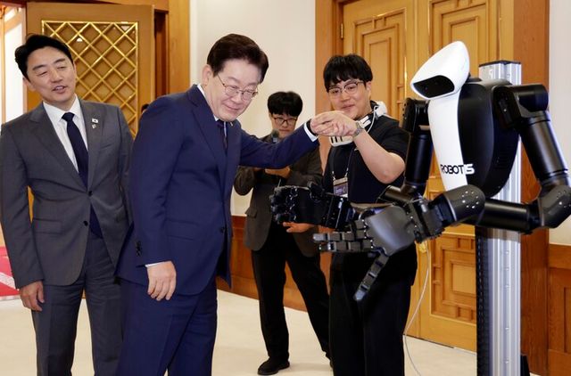 이재명 대통령이 26일 청와대에서 열린 '미래신안보 혁신기업 육성전략' 회의에 앞서 행사장 전시물인 휴머노이드 로봇을 보고 있다. [사진=연합뉴스]
