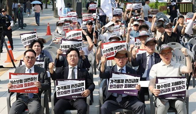 대한의사협회가 28일 서울 중구 대한문 앞에서 대한정형외과의사회, 대한신경외과의사회, 대한마취통증의학과의사회, 대한재활의학과의사회 등과 함께 연 도수치료 관리급여 전환 반대 궐기대회에서 참가자들이 구호를 외치고 있다. [사진=연합뉴스]