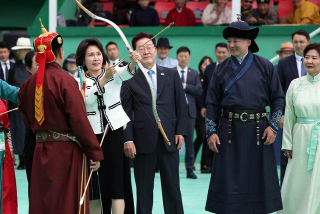 이재명 대통령과 몽골을 국빈 방문 중인 김혜경 여사가 11일(현지 시각) 나담축제가 열리고 있는 울란바타르 전통 활쏘기 경기장에서 이 대통령과 오흐나 후렐수흐 대통령, 롭상도르지 벌러르체첵 여사가 보는 가운데 전통 활을 쏘고 있다. [사진=연합뉴스]