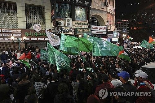 이스라엘에 수감됐던 팔레스타인인들의 귀환에 하마스 깃발을 흔들며 기뻐하는 팔레스타인인들