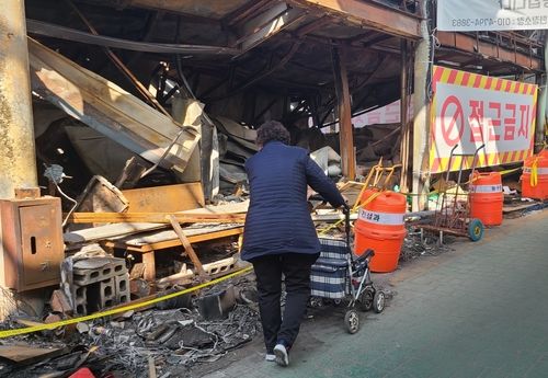 화재로 타 버린 가게 살펴보는 현대시장 상인 안씨