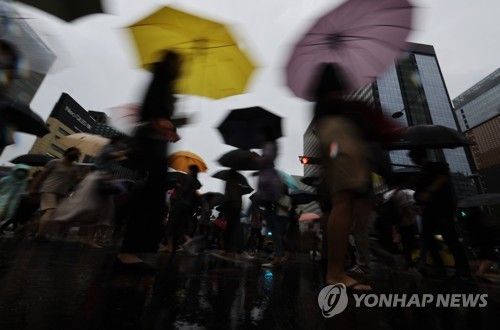 흐린 하늘 아래 춤추는 우산들