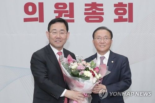 주호영 전 원내대표로부터 꽃다발 받는 윤재옥 신임 원내대표