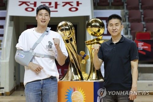 트로피 옆에서 포즈 취하는 김상식 감독과 양희종