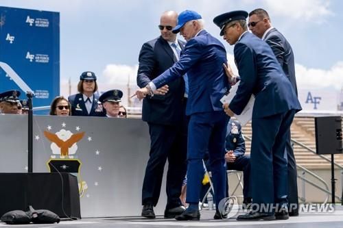 넘어졌다가 일어난 뒤 모래주머니를 가리키는 조 바이든 미국 대통령