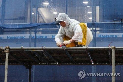 작년 9월 서울의 한 공사 현장에서 노동자가 비바람에 지붕이 날아가지 않도록 묶는 모습
