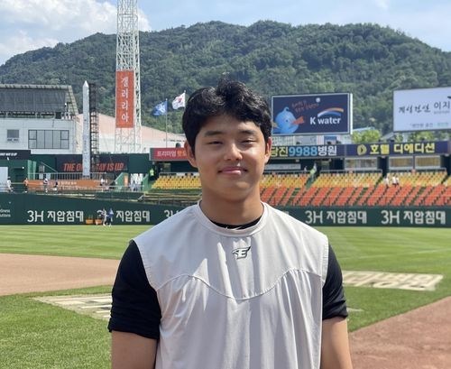 대전구장에서 누리호 모형(왼쪽)을 배경으로 포즈를 취한 한화 문동주