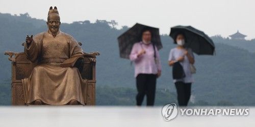 서울 광화문광장에서 우산을 쓴 시민들이 길을 지나고 있다.[연합뉴스 자료사진]