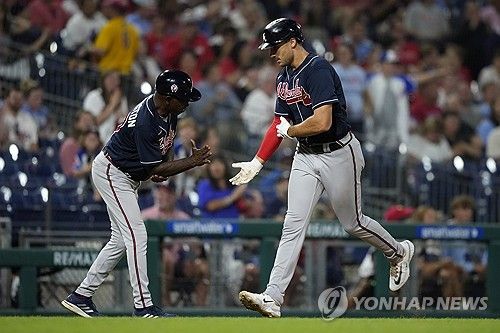 코치의 축하를 받으며 홈에 들어오는 맷 올슨