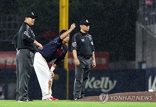 비 내리는 그라운드 살피는 심판진