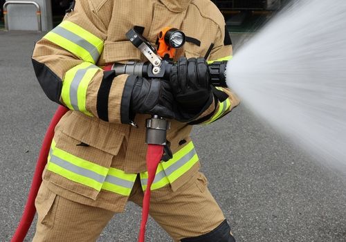 소화 호스가 아래쪽 밸브에 연장된 상태로 물을 분사하는 바이패스 관창