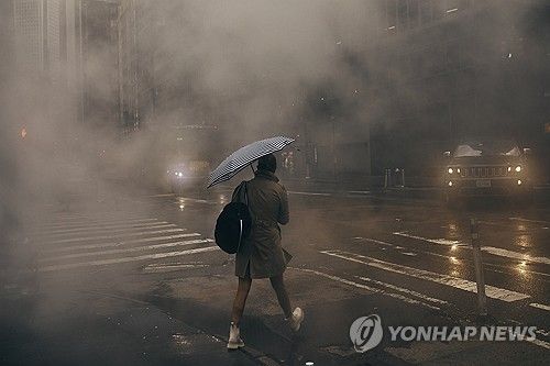 폭우 속에서 길을 건너는 뉴욕 시민