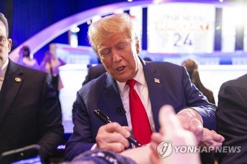 지지자 팔에 사인해주는 트럼프