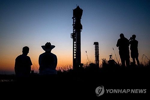 12일(현지시간) 미국 텍사스주 보카 치카 인근 발사대에 놓인 스페이스X 스타십을 바라보는 방문객들. 