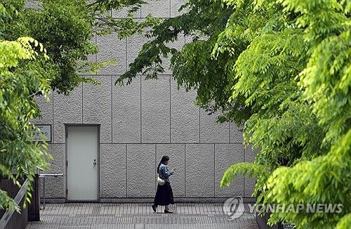 일본 도쿄 신주쿠 빌딩 앞 걷는 여성