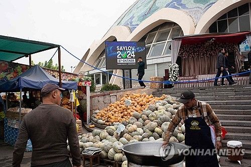 타슈켄트 시장에 설치된 총선 홍보 전광판