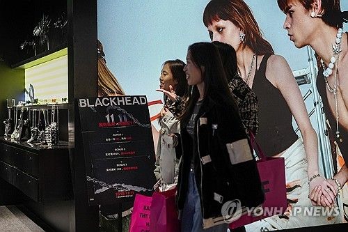 중국 베이징의 쇼핑센터에서 광군제 광고판 앞을 지나는 쇼핑객