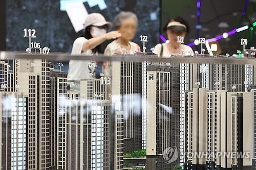 서울의 한 아파트 견본주택에서 방문객들이 단지 모형을 살펴보고 있다.