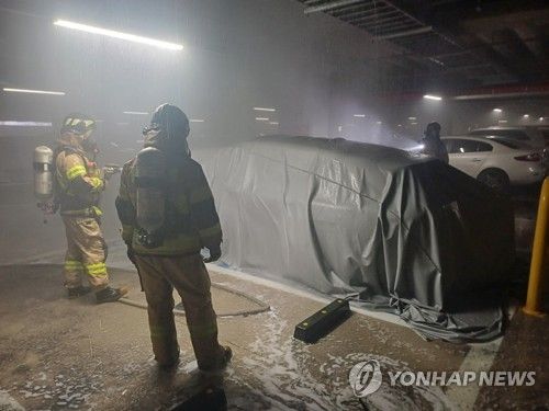 불난 전기차 질식소화포로 덮은 소방대원들