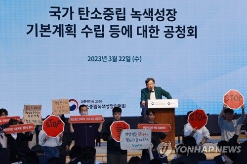 작년 3월 22일 제1차 국가 탄소중립 녹색성장 기본계획 수립 공청회 때 환경단체 회원들이 손팻말을 들고 항의하고 있다. [연합뉴스 자료사진]