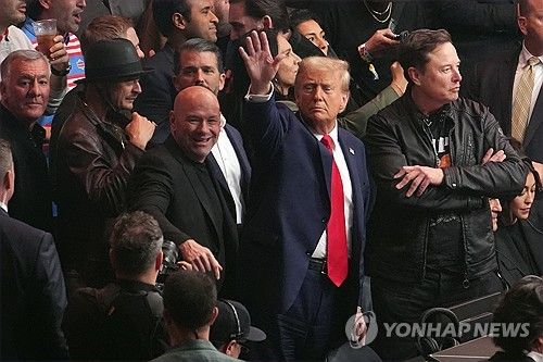 관객을 향해 손을 들어 인사하는 도널드 트럼프 당선인 