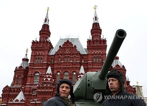지난 8일 러시아 붉은광장에 전시된 전차 앞에서 포즈 취한 모스크바 시민들