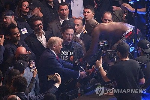 도널드 트럼프 당선인에게 챔피언 벨트를 건네는 존 존스