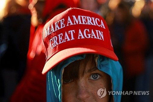 트럼프 선거 구호를 적은 모자를 쓴 지지자
