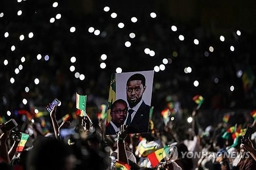 바시루 디오마예 파예 대통령과 우스만 송코 총리 사진을 든 파스테프 지지자들