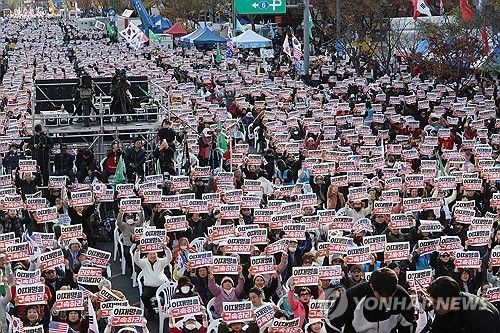 손팻말 들고 구호 외치는 집회 참가자들