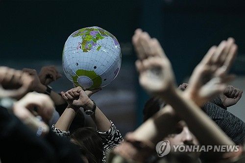 22일(현지시간) COP29 회의에서 활동가들이 합의문 초안에 반대하는 침묵 시위를 하는 모습